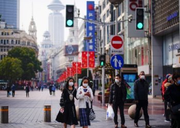 FILE PHOTO: People wearing face masks walk at a main shopping area, following the coronavirus disease (COVID-19) outbreak in Shanghai, China January 27, 2021. REUTERS/Aly Song/File Photo