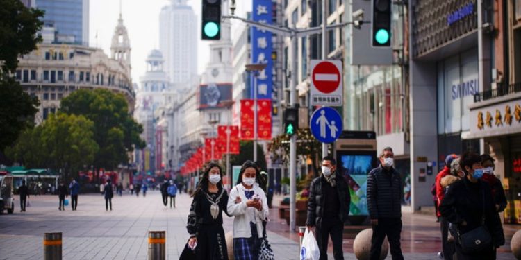 FILE PHOTO: People wearing face masks walk at a main shopping area, following the coronavirus disease (COVID-19) outbreak in Shanghai, China January 27, 2021. REUTERS/Aly Song/File Photo